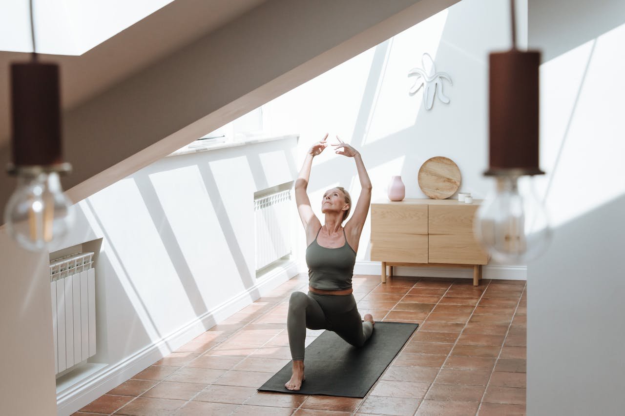 Senior woman stretches gracefully in an inviting sunlit room, embodying a healthy lifestyle.